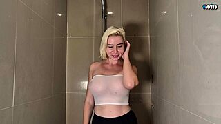 this blonde babe with huge tits teases in the shower wearing a transparent top that clings when wet.