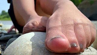 goddess in tan nylons shows her cute nylon soles and toes on the riverside