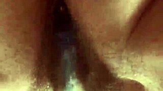 She masturbates her hairy pussy with a glass dildo up close